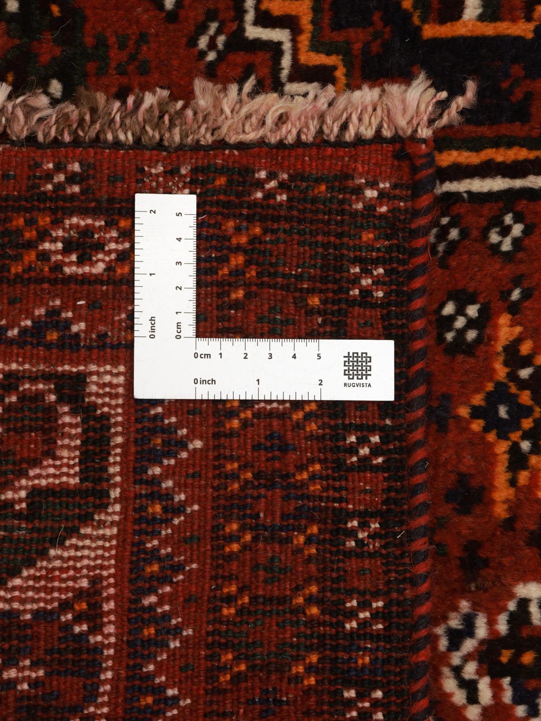 A hand-knotted Shiraz rug from the Middle East featuring a dark-red field with geometric medallions.