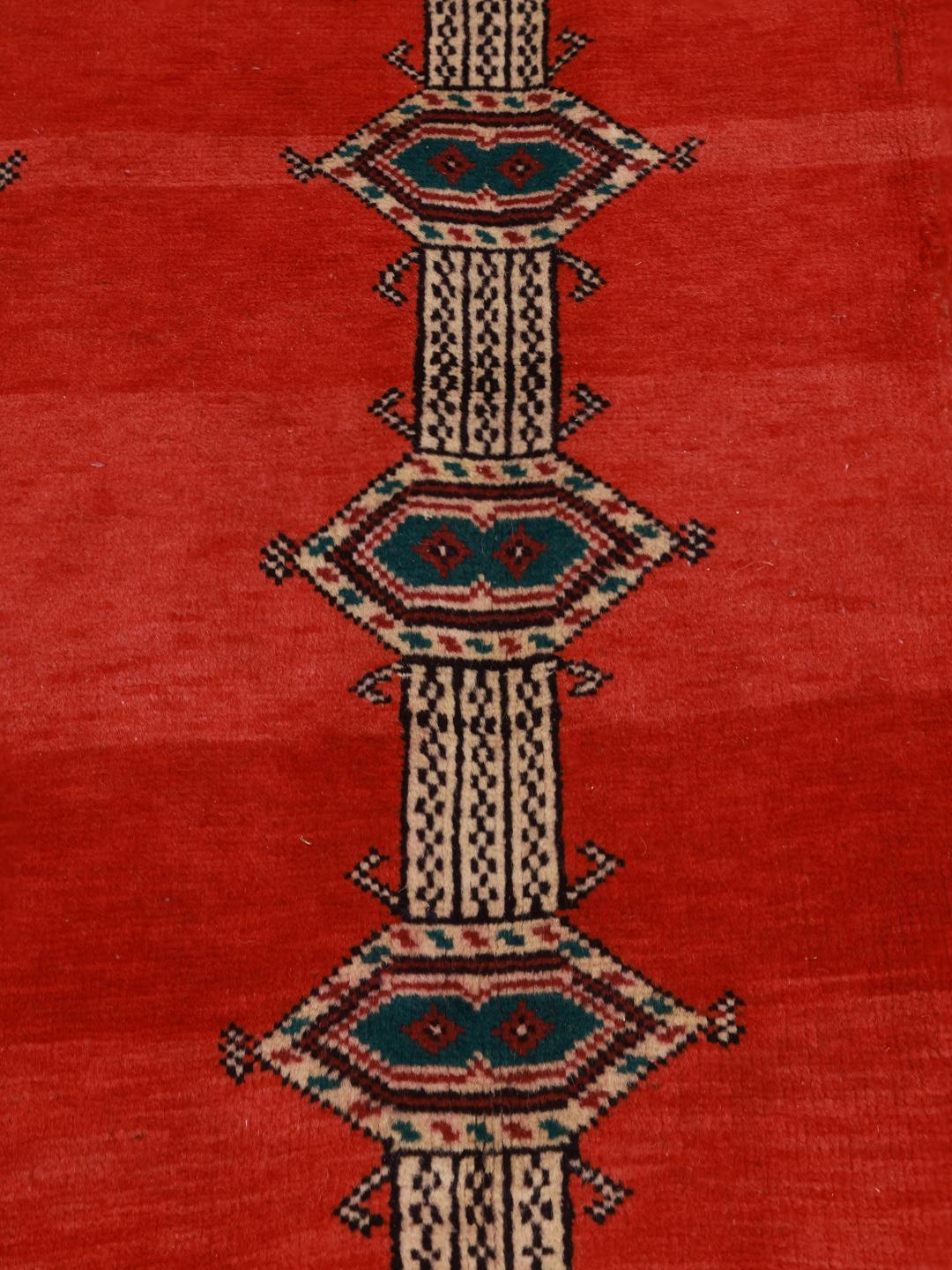 A hand-knotted Shiraz rug from the Middle East featuring a red field with geometric motifs.