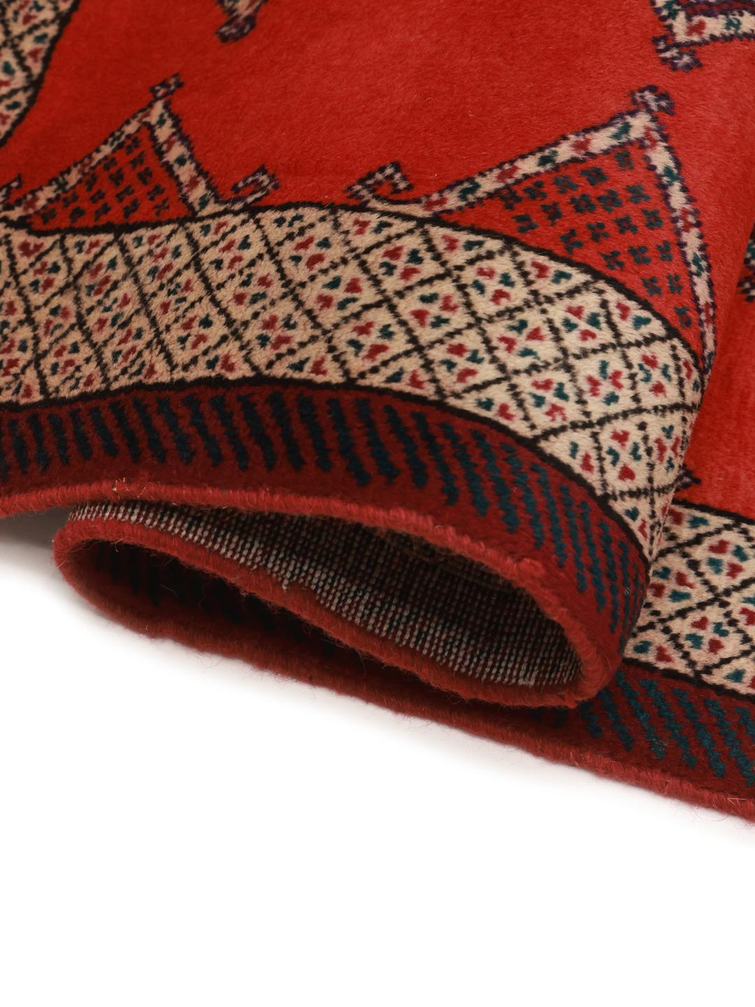A hand-knotted Shiraz rug from the Middle East featuring a red field with geometric motifs.
