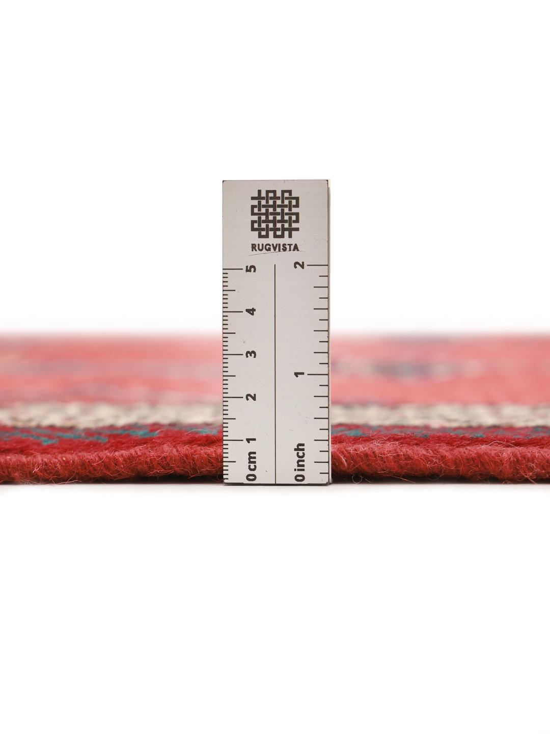 A hand-knotted Shiraz rug from the Middle East featuring a red field with geometric motifs.