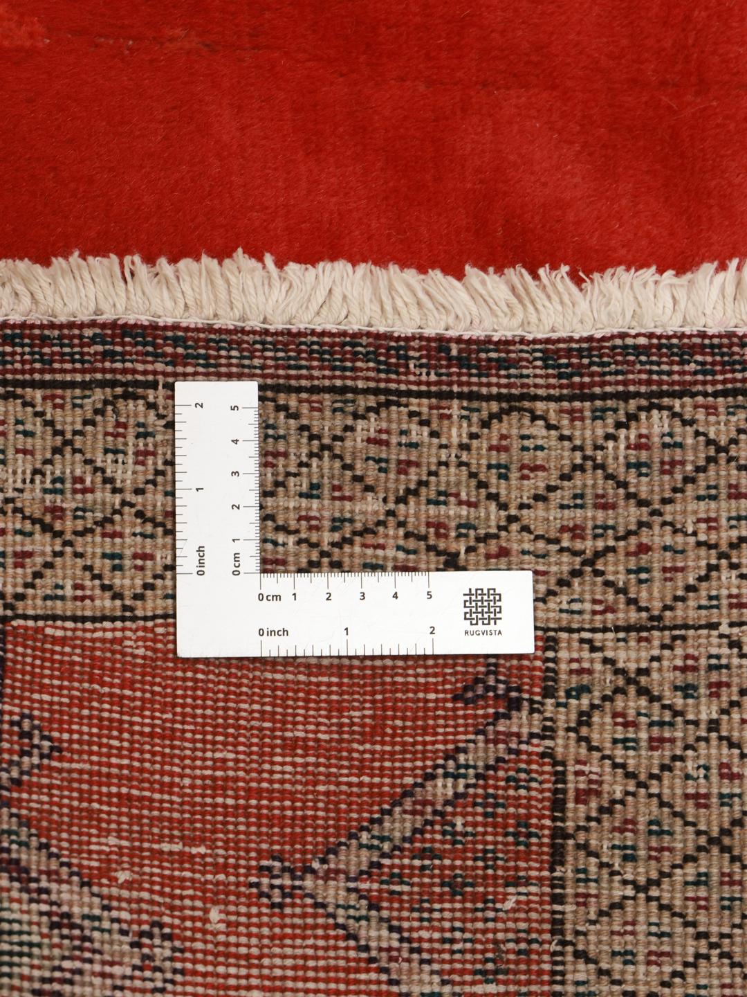 A hand-knotted Shiraz rug from the Middle East featuring a red field with geometric motifs.