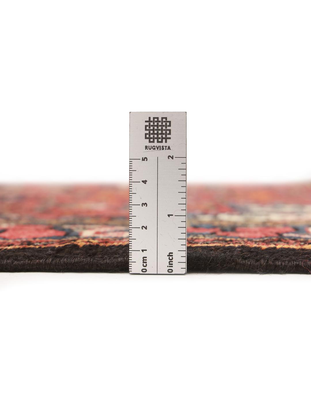 A hand-knotted Hosseinabad wool rug from the Middle East featuring a red field and central medallion.