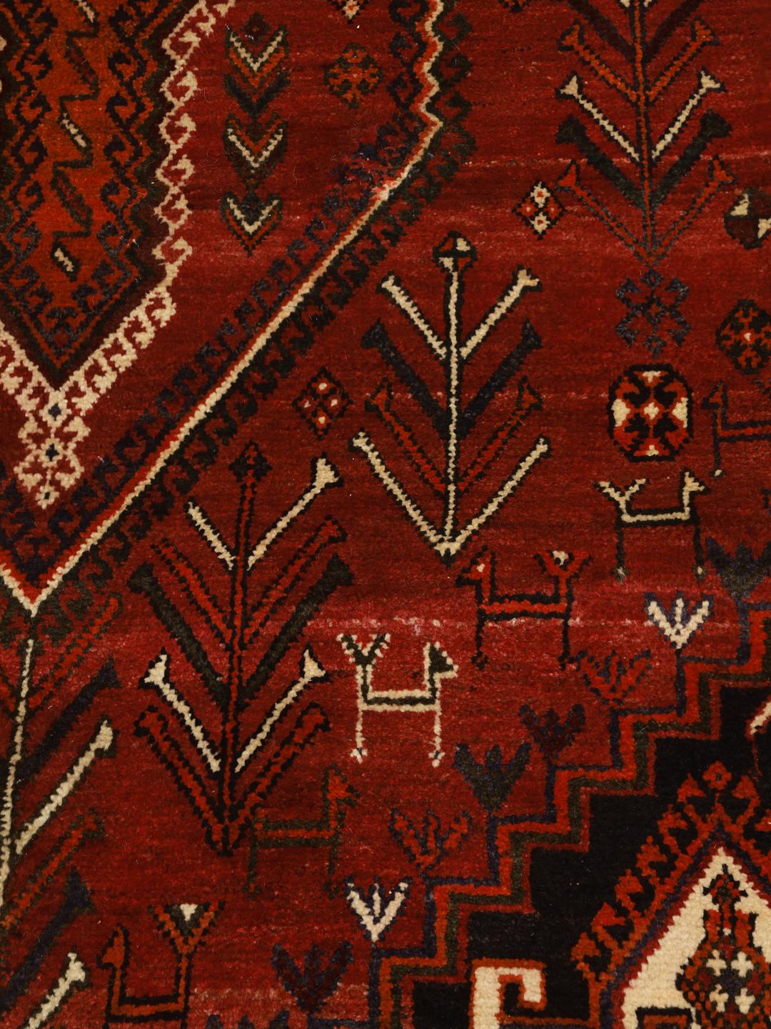 A hand knotted Ghashghai rug from the Middle East featuring a vibrant red and black design
