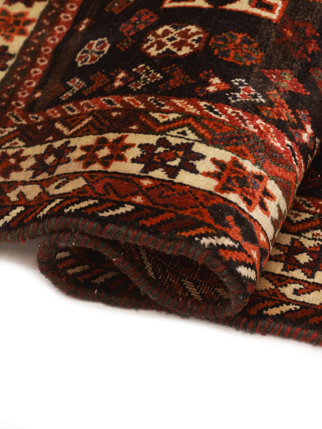 A hand knotted Ghashghai rug from the Middle East featuring a vibrant red and black design