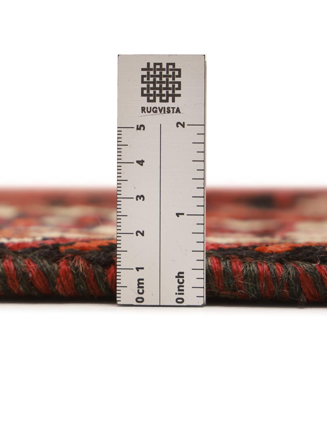 A hand knotted Ghashghai rug from the Middle East featuring a vibrant red and black design