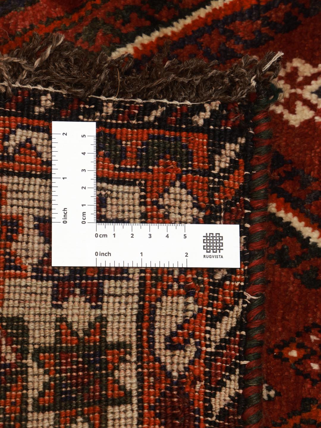 A hand knotted Ghashghai rug from the Middle East featuring a vibrant red and black design