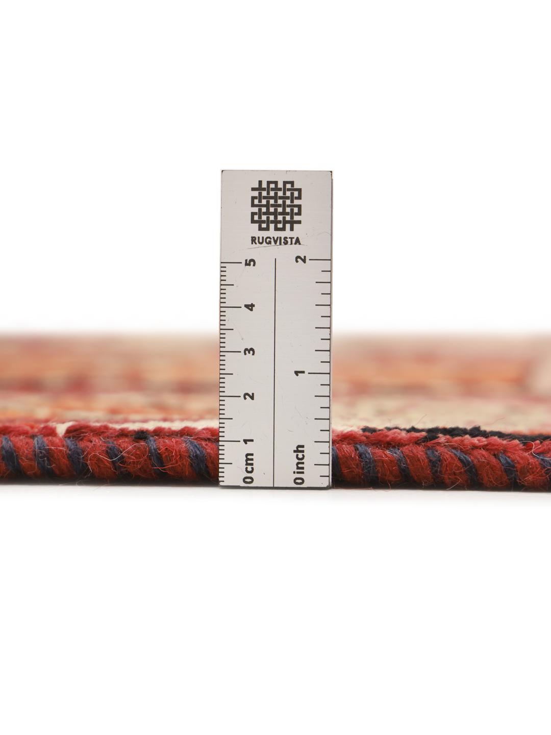 A hand-knotted Qashqai rug from the Middle East featuring a vibrant red field with geometric floral motifs.