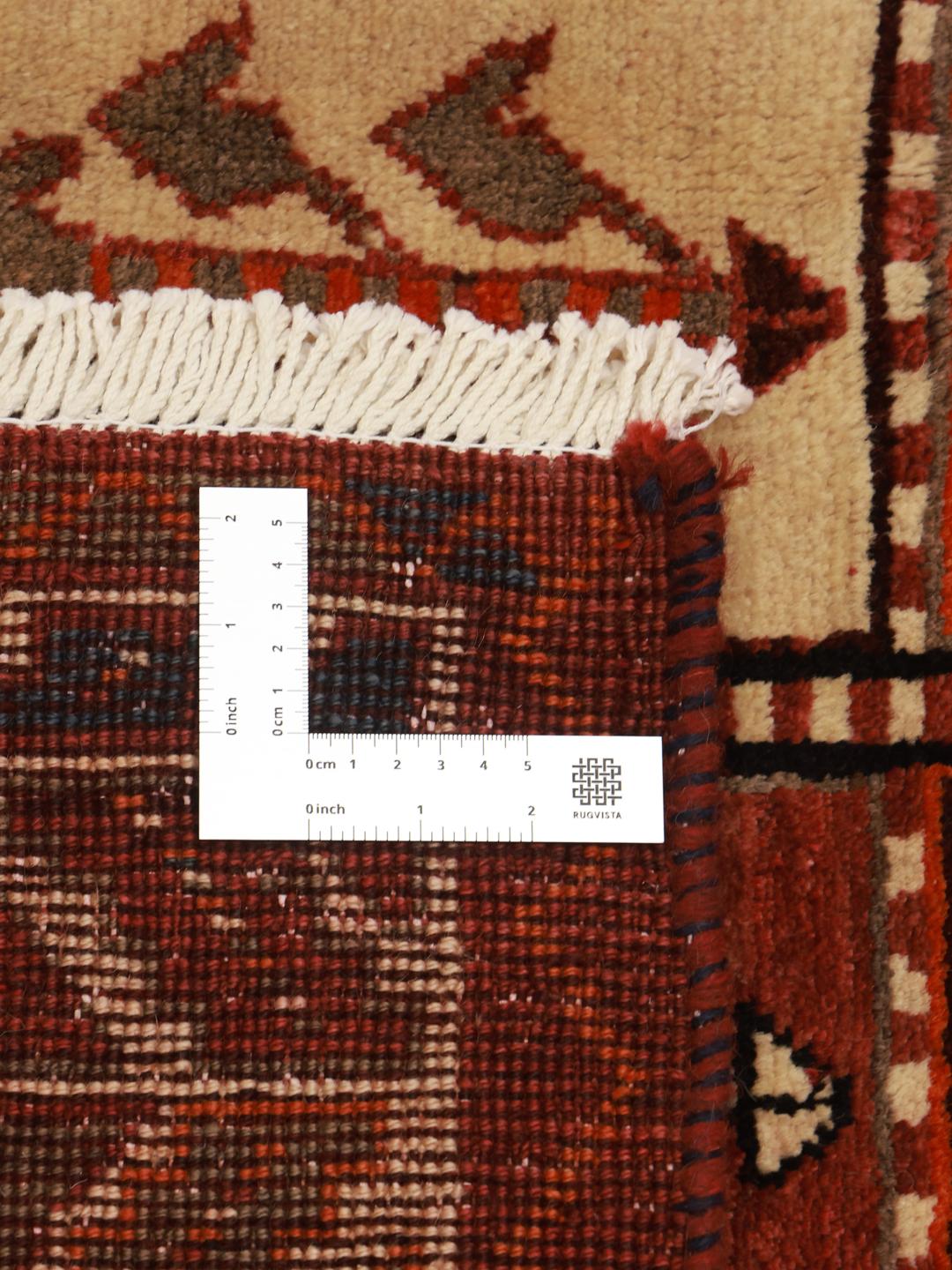 A hand-knotted Qashqai rug from the Middle East featuring a vibrant red field with geometric floral motifs.