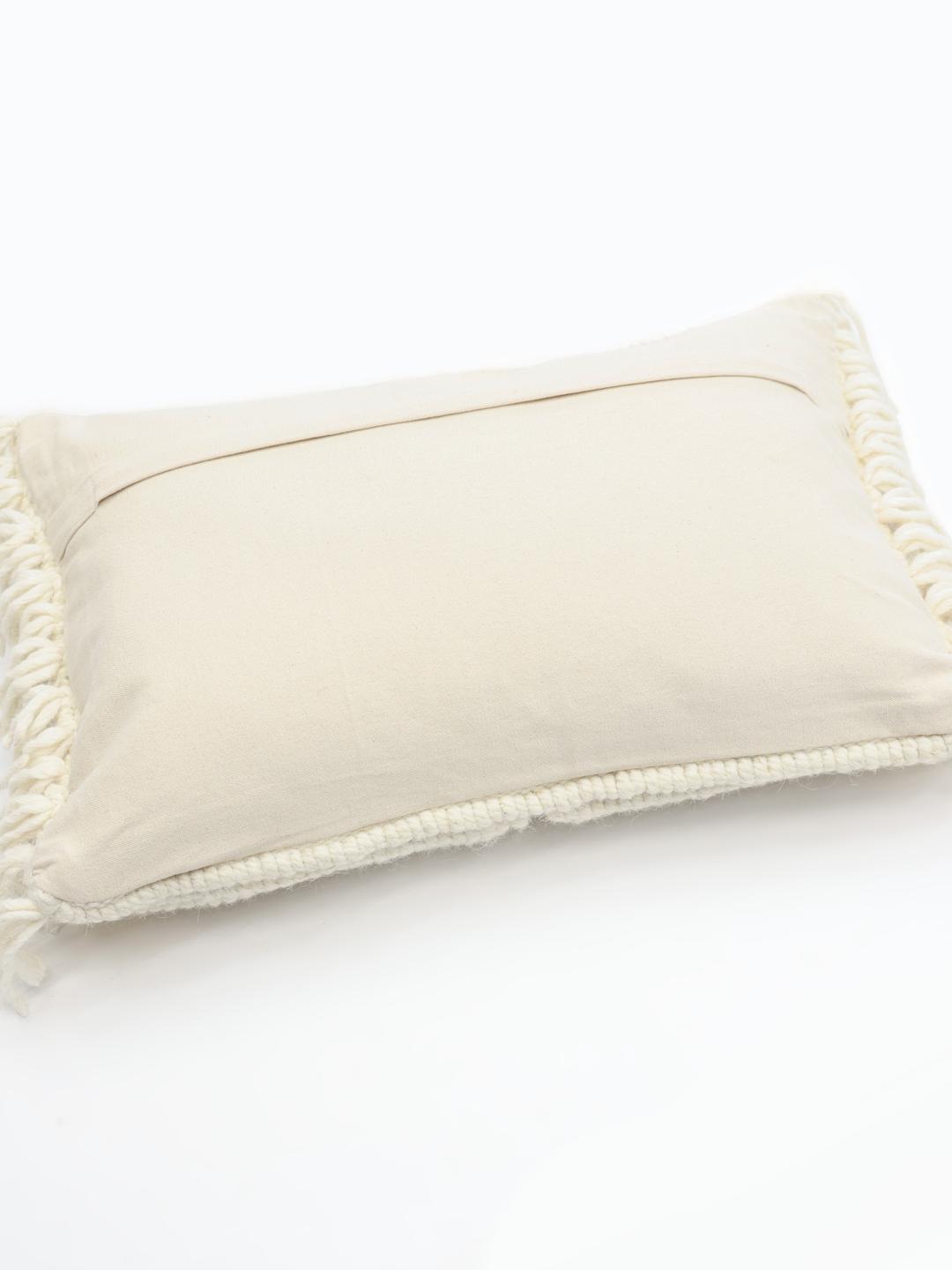 Witte kussenhoes met een handgeweven wollen textuur en franjes.