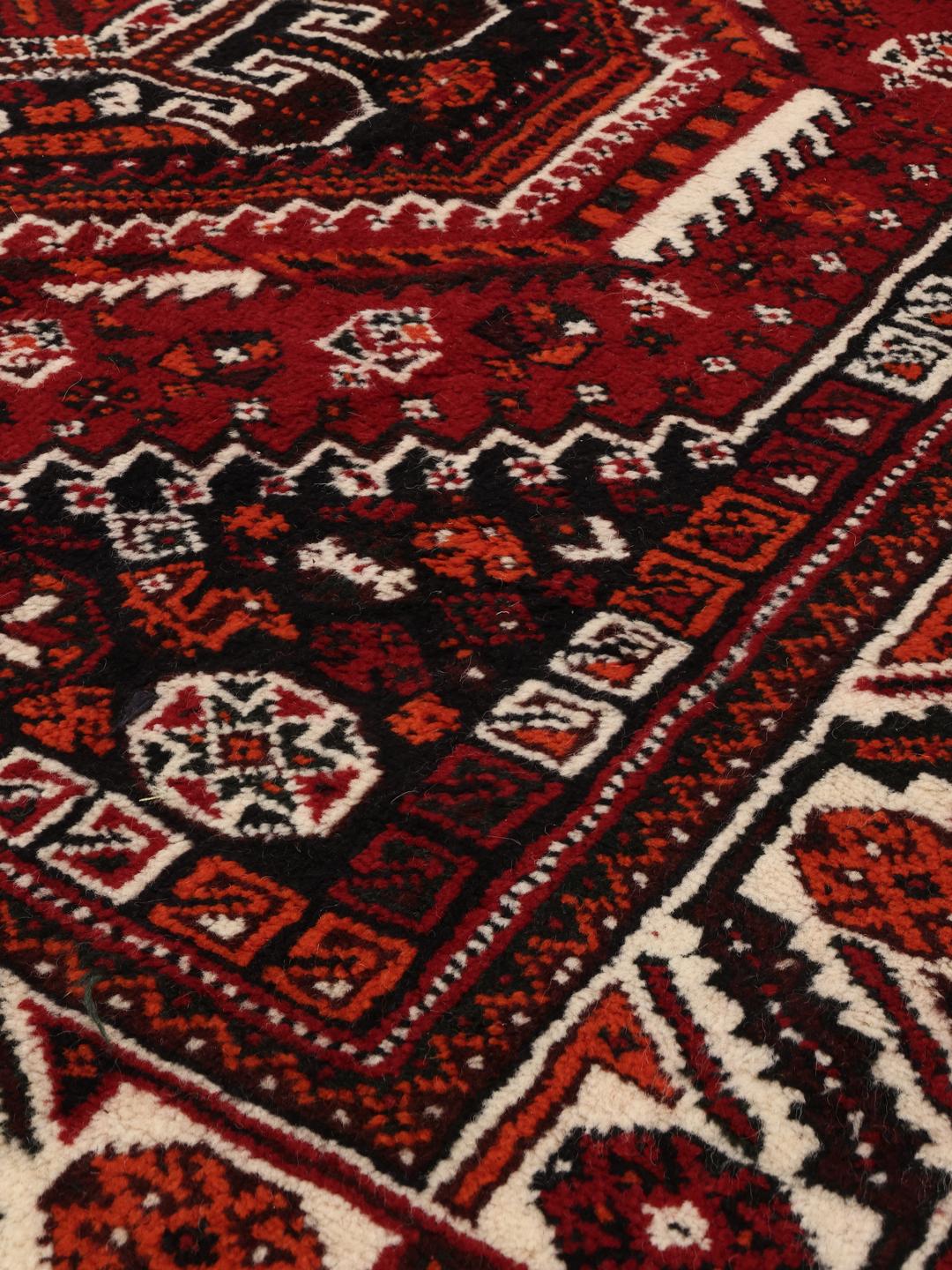 Hand-knotted Middle Eastern rug in dark-red with geometric medallion patterns