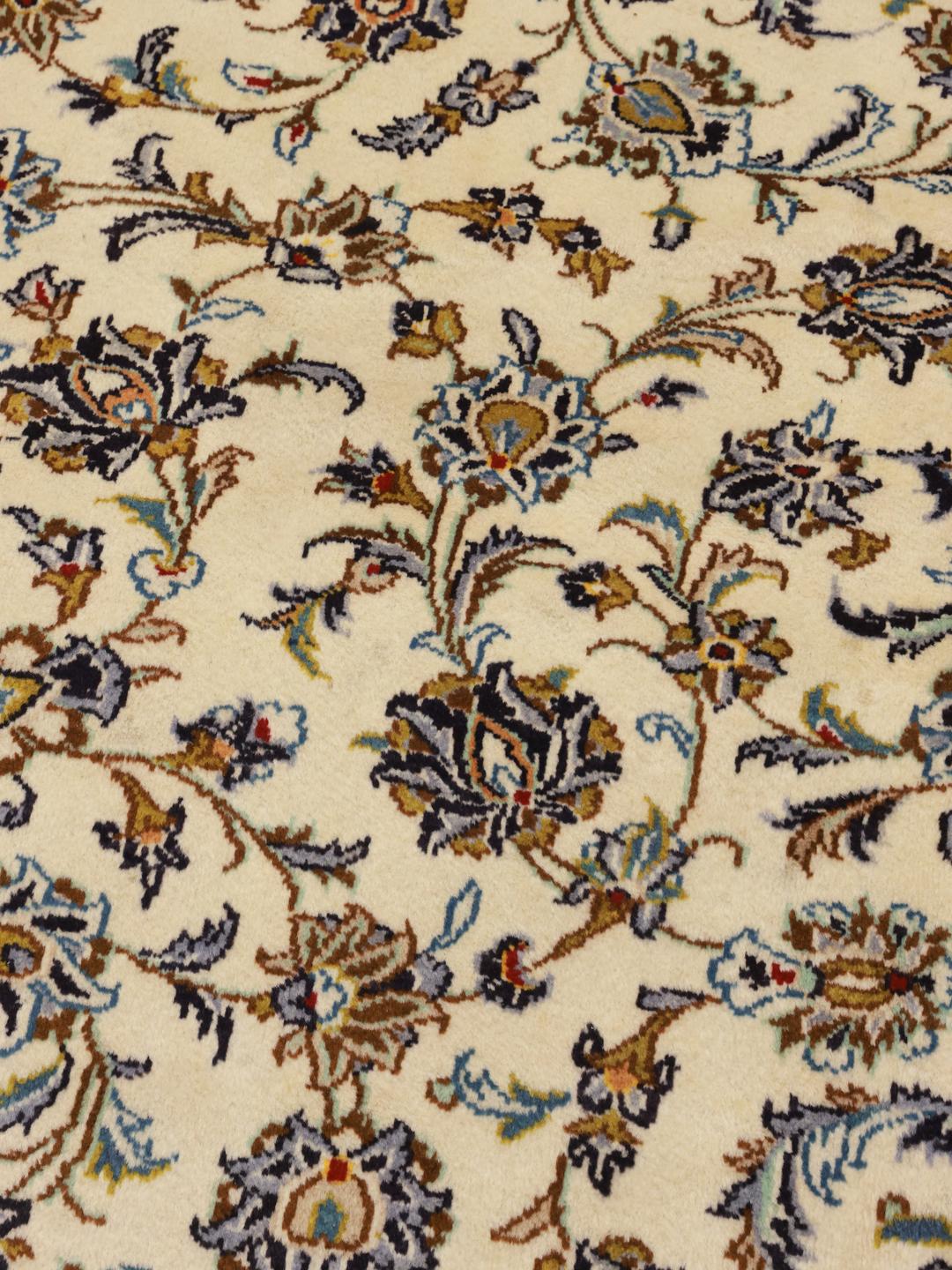 Et stort rektangulært Keshan-tæppe fra Mellemøsten med beige baggrund og indviklede blomstermønstre.