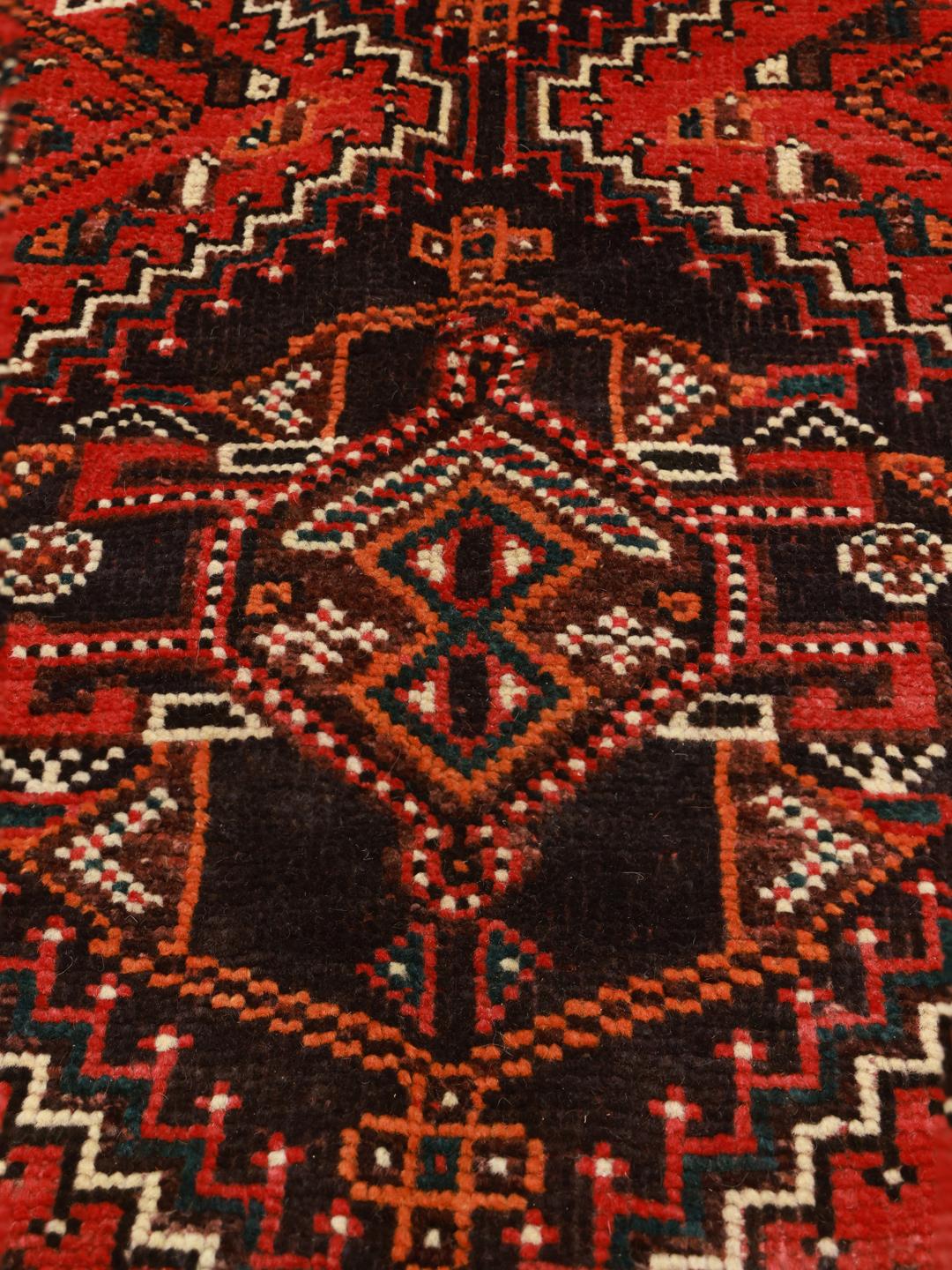 Hand-knotted Middle Eastern rug in dark-red and black tones