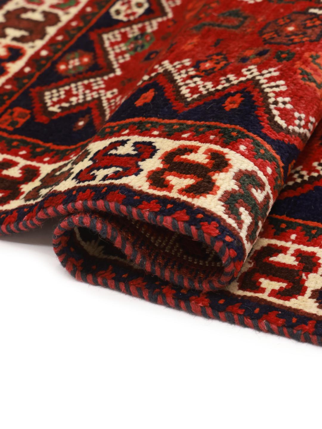 Hand-knotted Shiraz rug from the Middle East featuring a vibrant red field and tribal motifs