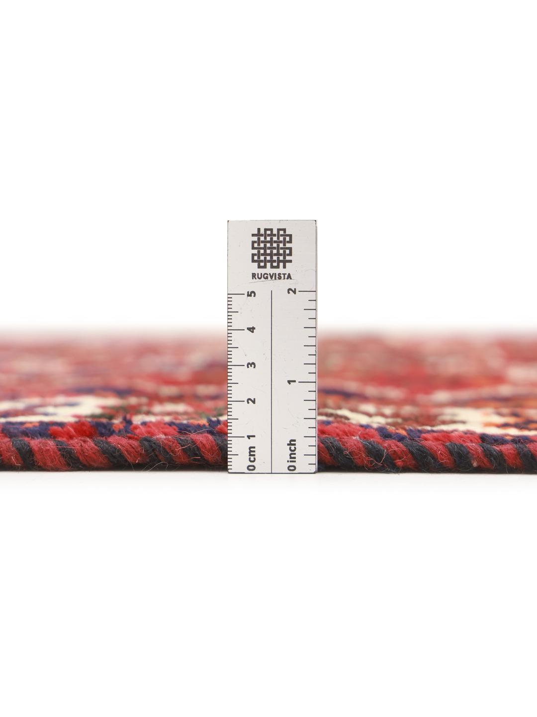 Hand-knotted Shiraz rug from the Middle East featuring a vibrant red field and tribal motifs