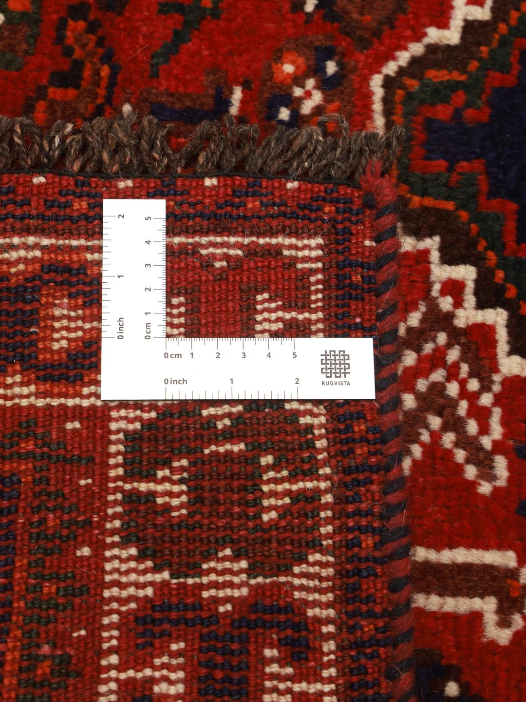 Hand-knotted Shiraz rug from the Middle East featuring a vibrant red field and tribal motifs