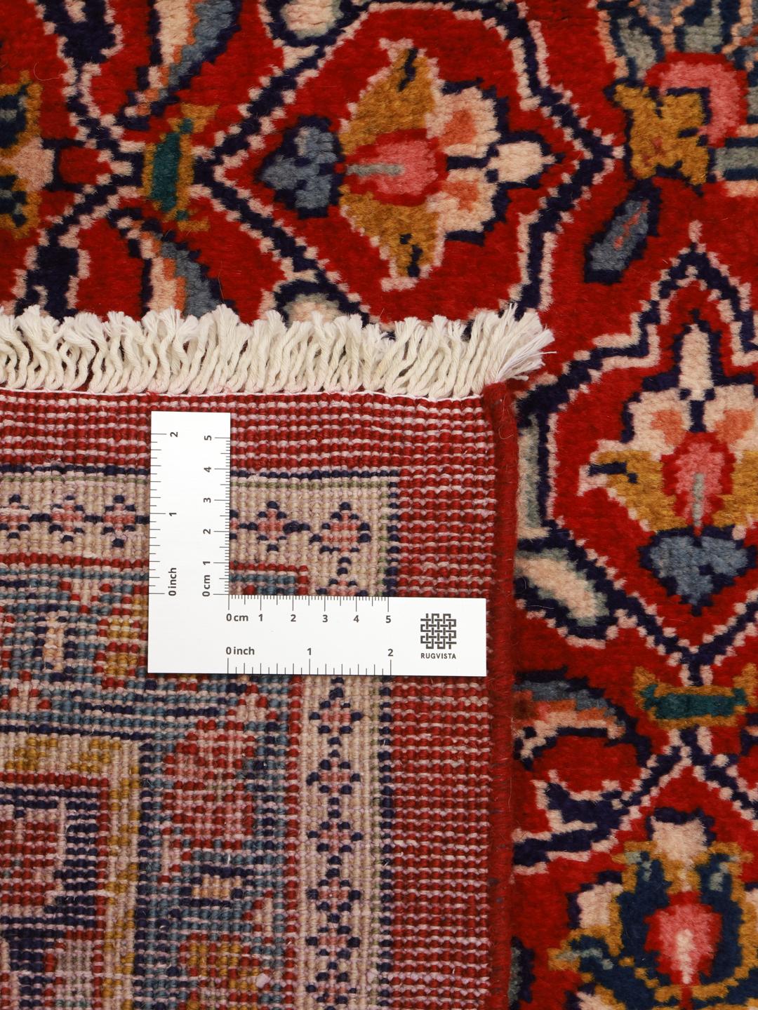 A hand-knotted Sarough rug from the Middle East featuring a vibrant red field with intricate floral patterns.