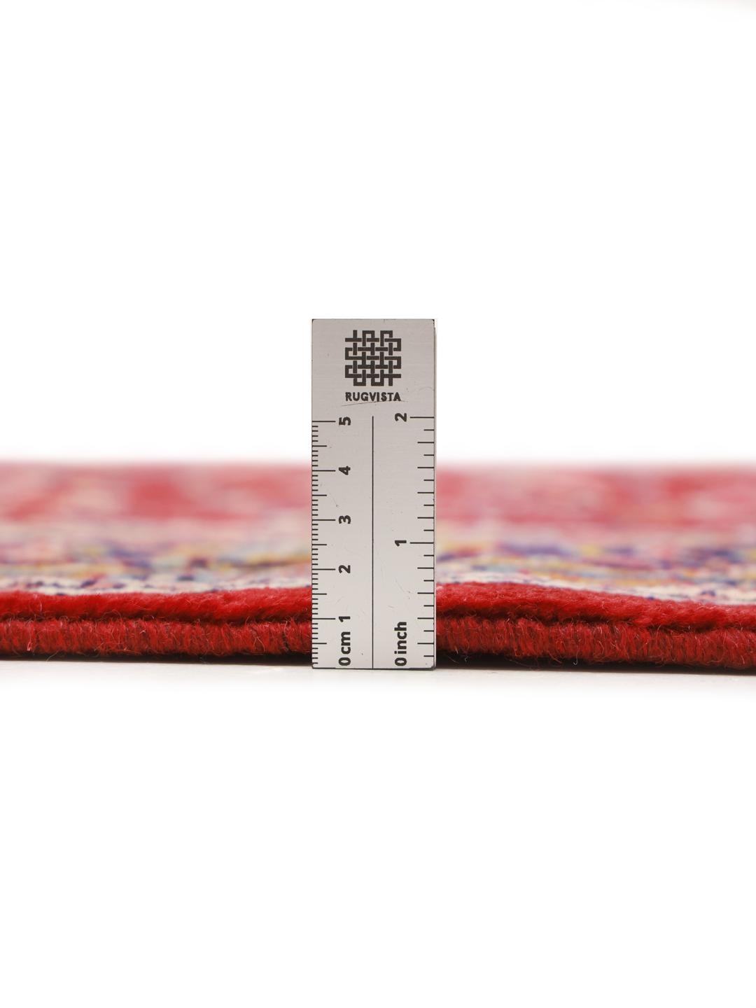 A hand-knotted Sarough rug from the Middle East featuring a vibrant red field with intricate floral patterns.
