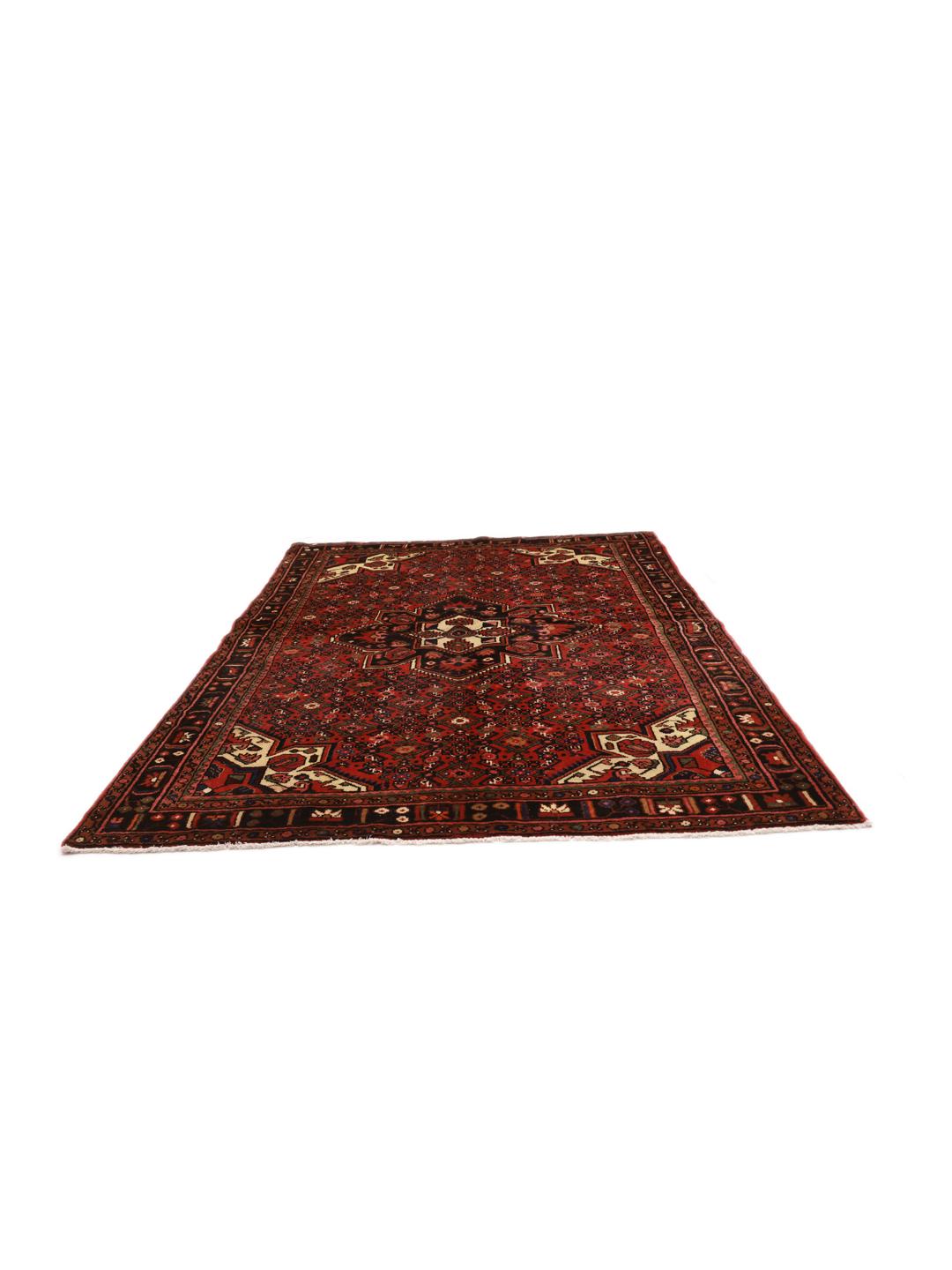 A hand-knotted Hosseinabad rug from the Middle East in deep red and dark blue tones.