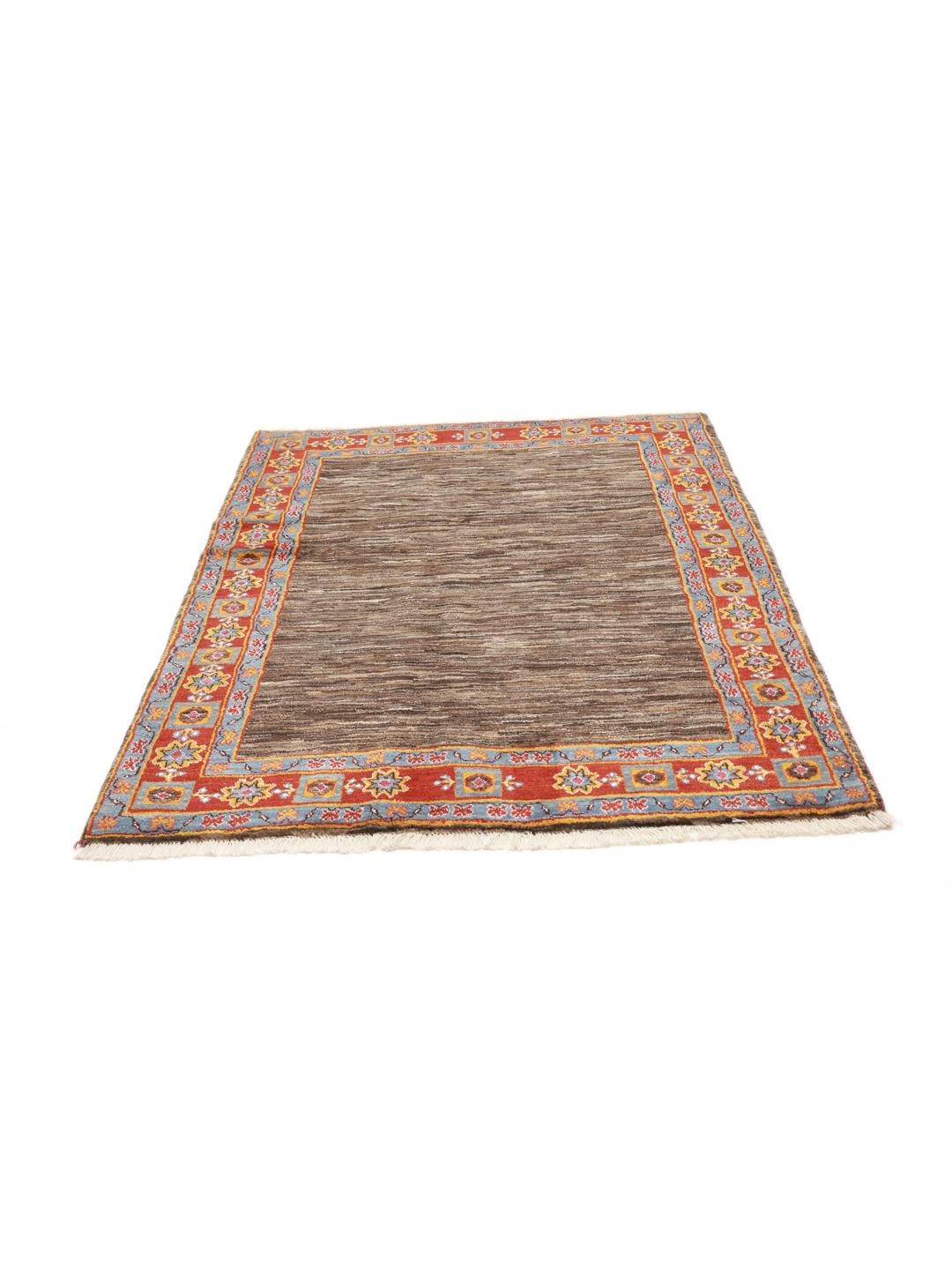 A rectangular Gabbeh rug from the Middle East with a brown field and vibrant border.