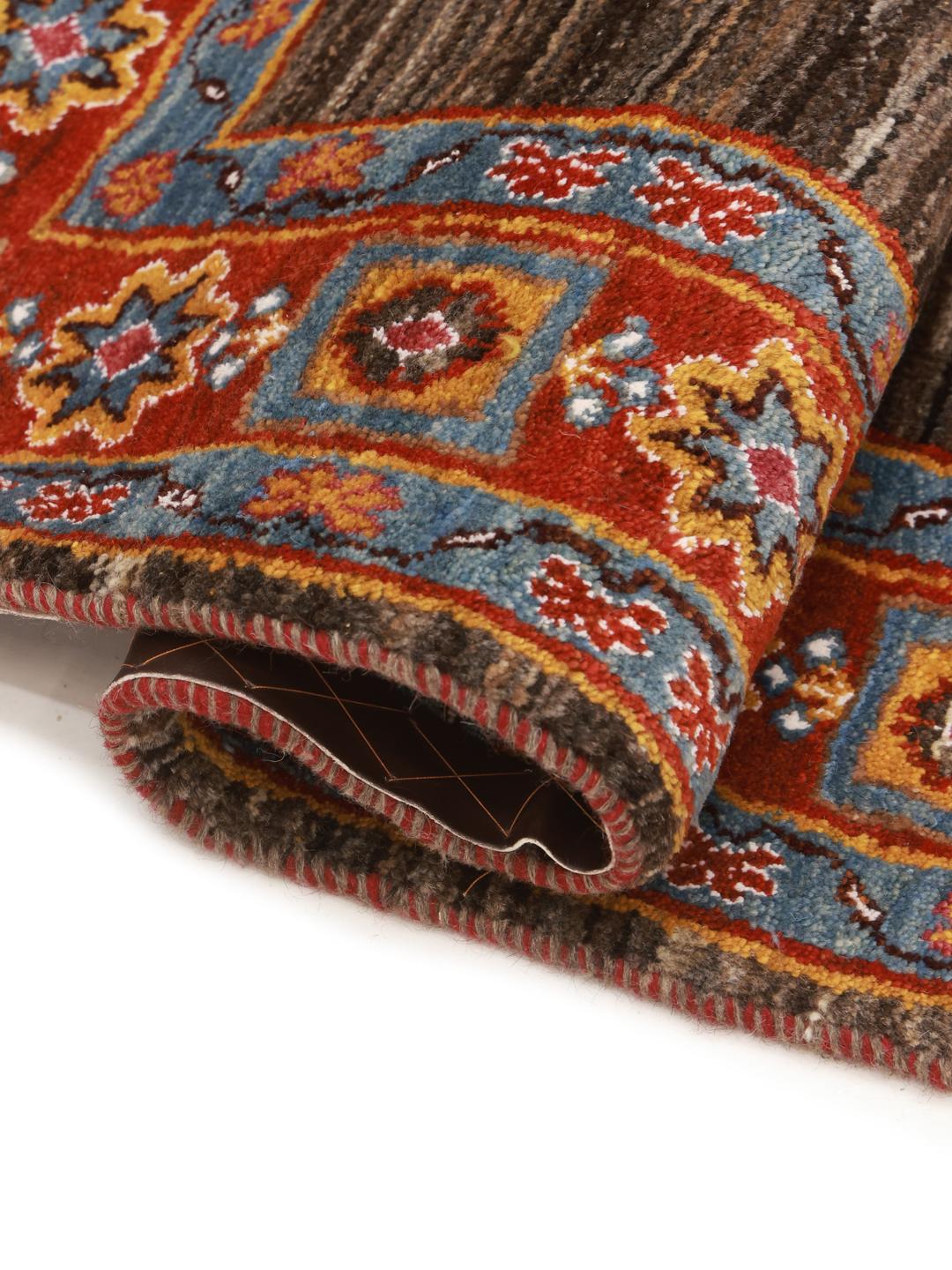 A rectangular Gabbeh rug from the Middle East with a brown field and vibrant border.