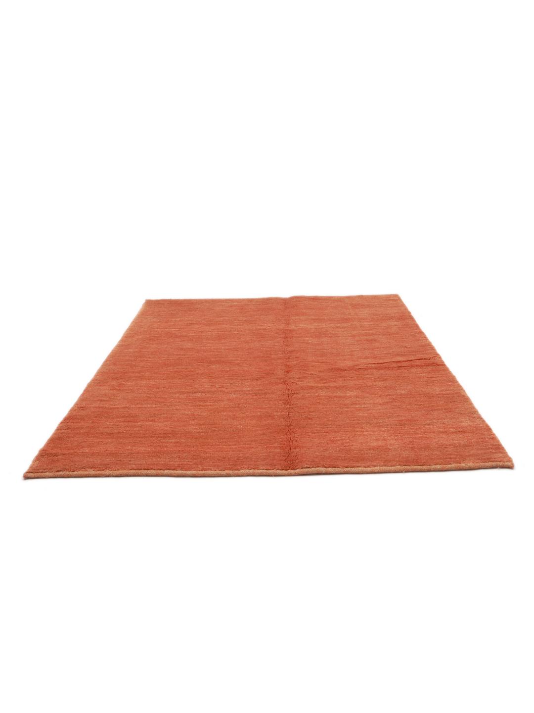 Een rechthoekig oranje Gabbeh-tapijt uit het Midden-Oosten met een effen ontwerp.