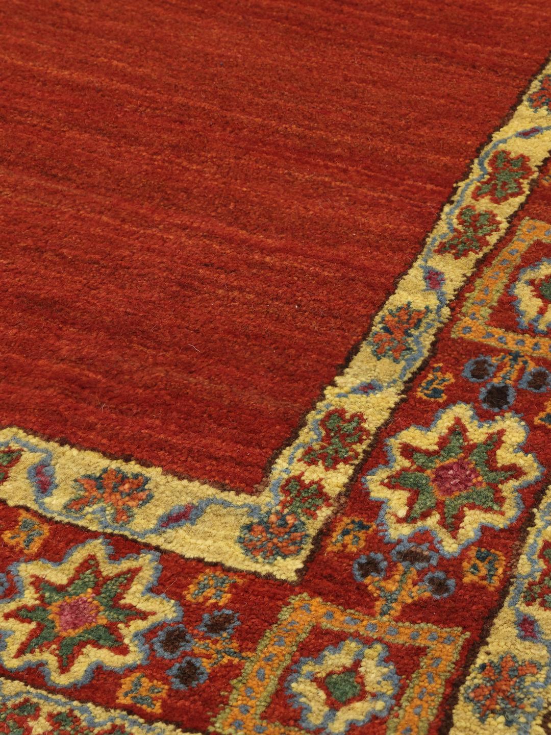 A hand-knotted Gabbeh Wool rug from the Middle East featuring a vibrant red field and geometric borders.