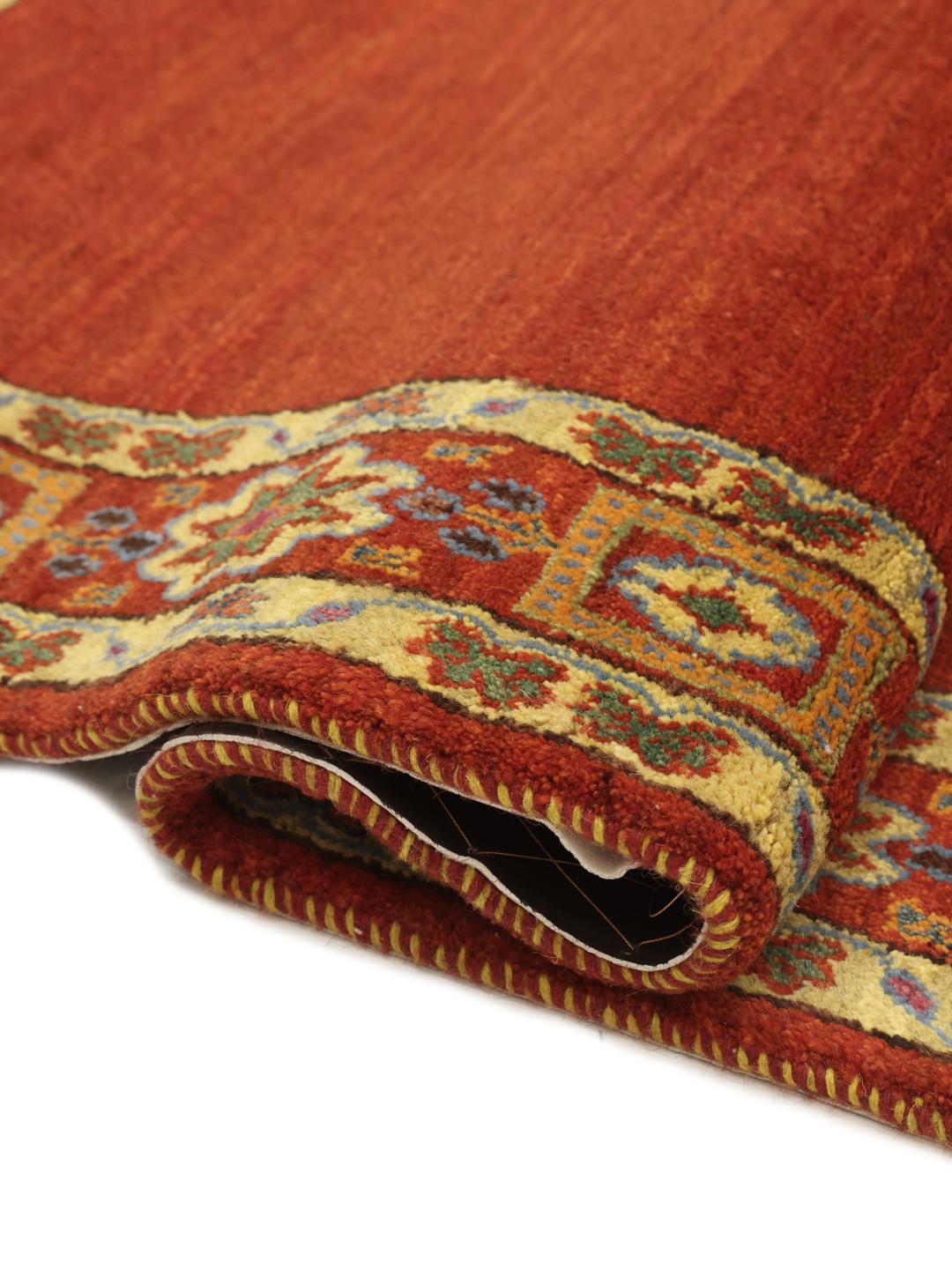 A hand-knotted Gabbeh Wool rug from the Middle East featuring a vibrant red field and geometric borders.
