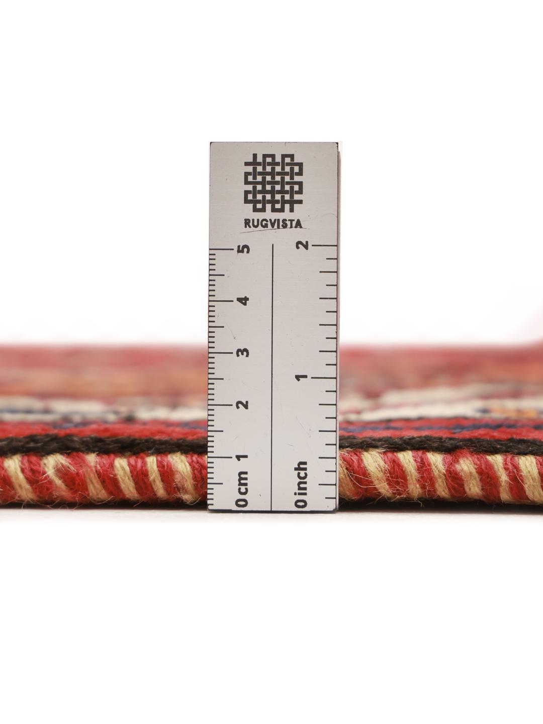 Hand-knotted Qashqai rug from the Middle East featuring a dark-red field and geometric patterns.