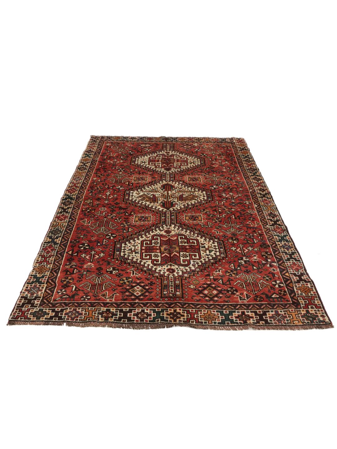 Hand knotted Shiraz rug from the Middle East featuring a vibrant red field with geometric medallions
