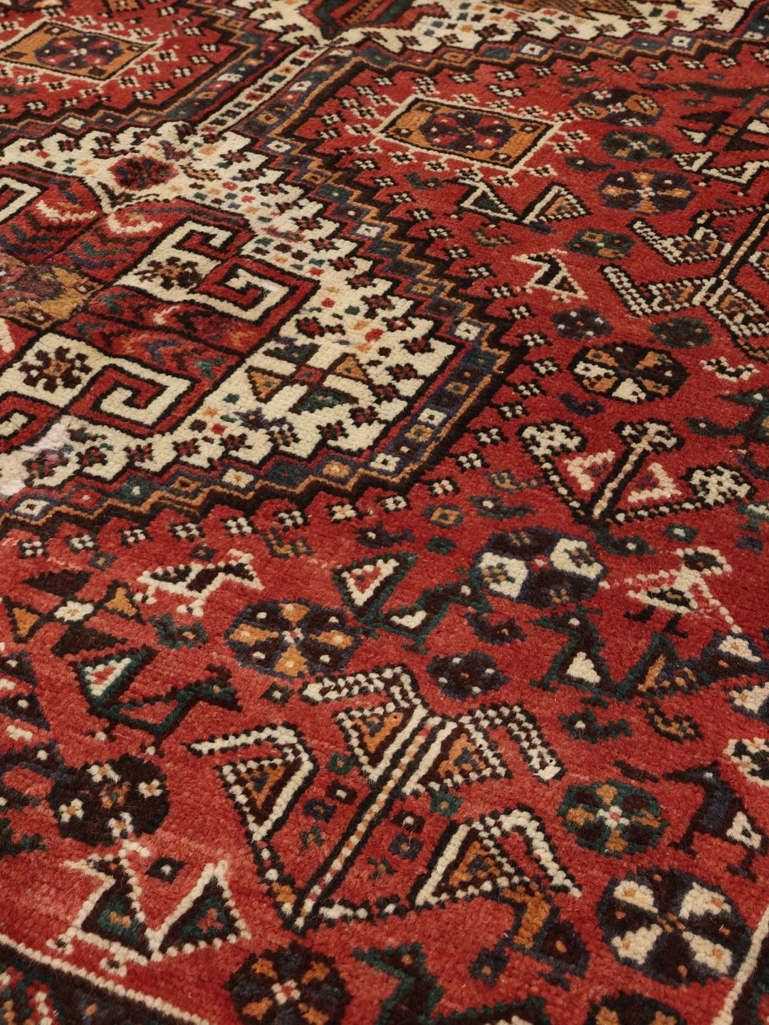 Hand knotted Shiraz rug from the Middle East featuring a vibrant red field with geometric medallions