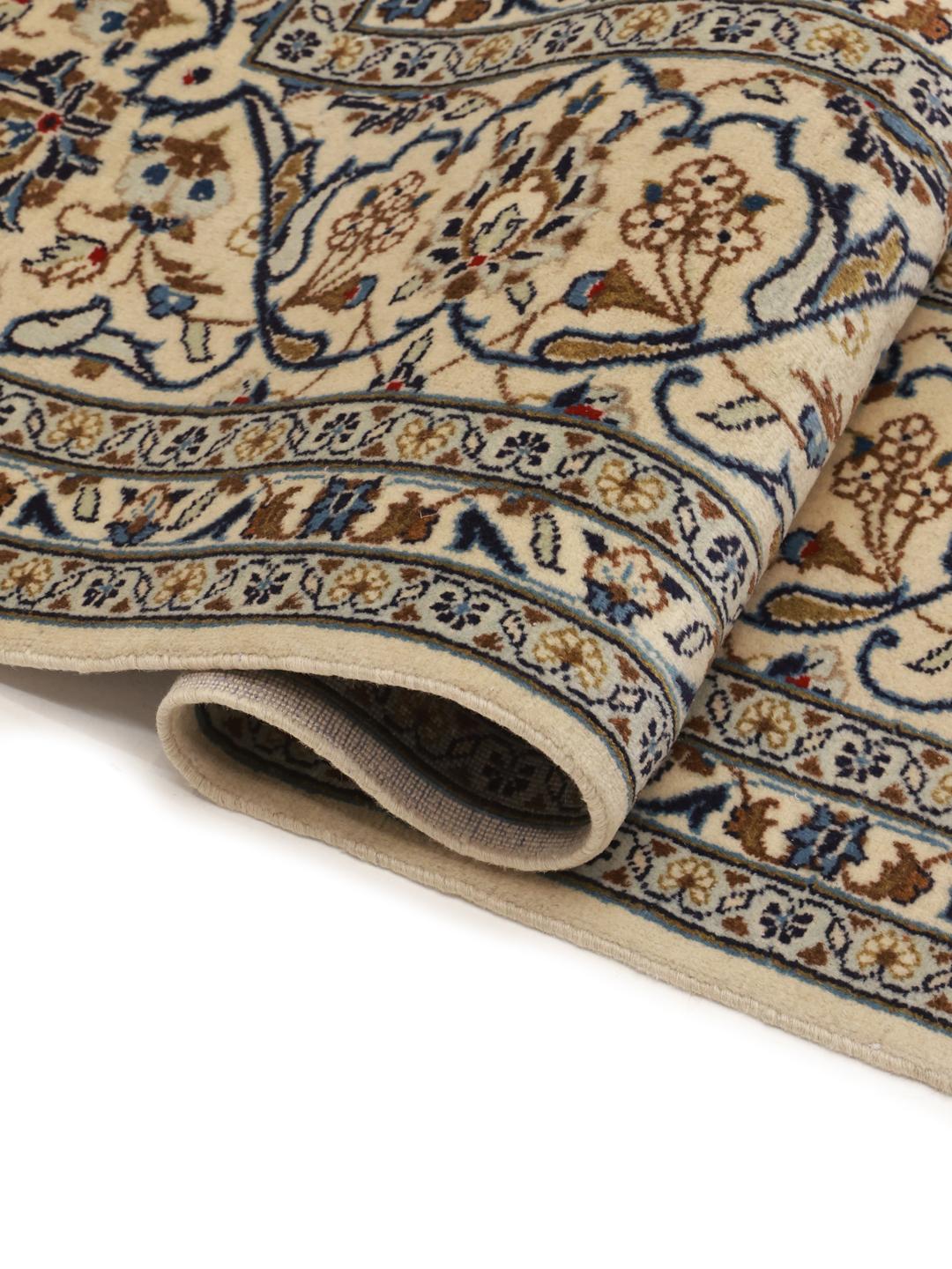 A rectangular Keshan rug from the Middle East featuring beige, blue, and brown floral patterns.