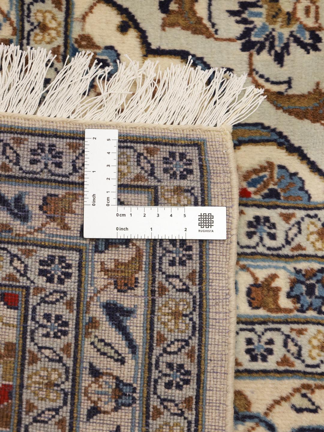 A rectangular Keshan rug from the Middle East featuring beige, blue, and brown floral patterns.