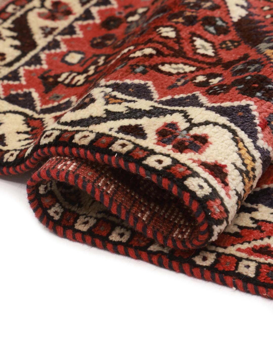 Hand-knotted Shiraz rug from the Middle East featuring a vibrant red field and geometric patterns.