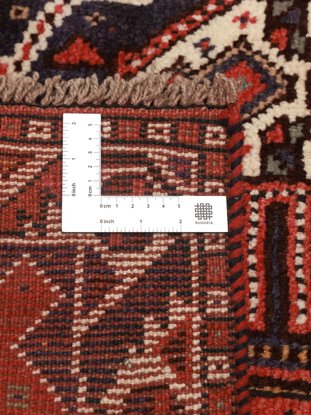 Hand-knotted Shiraz rug from the Middle East featuring a vibrant red field and geometric patterns.