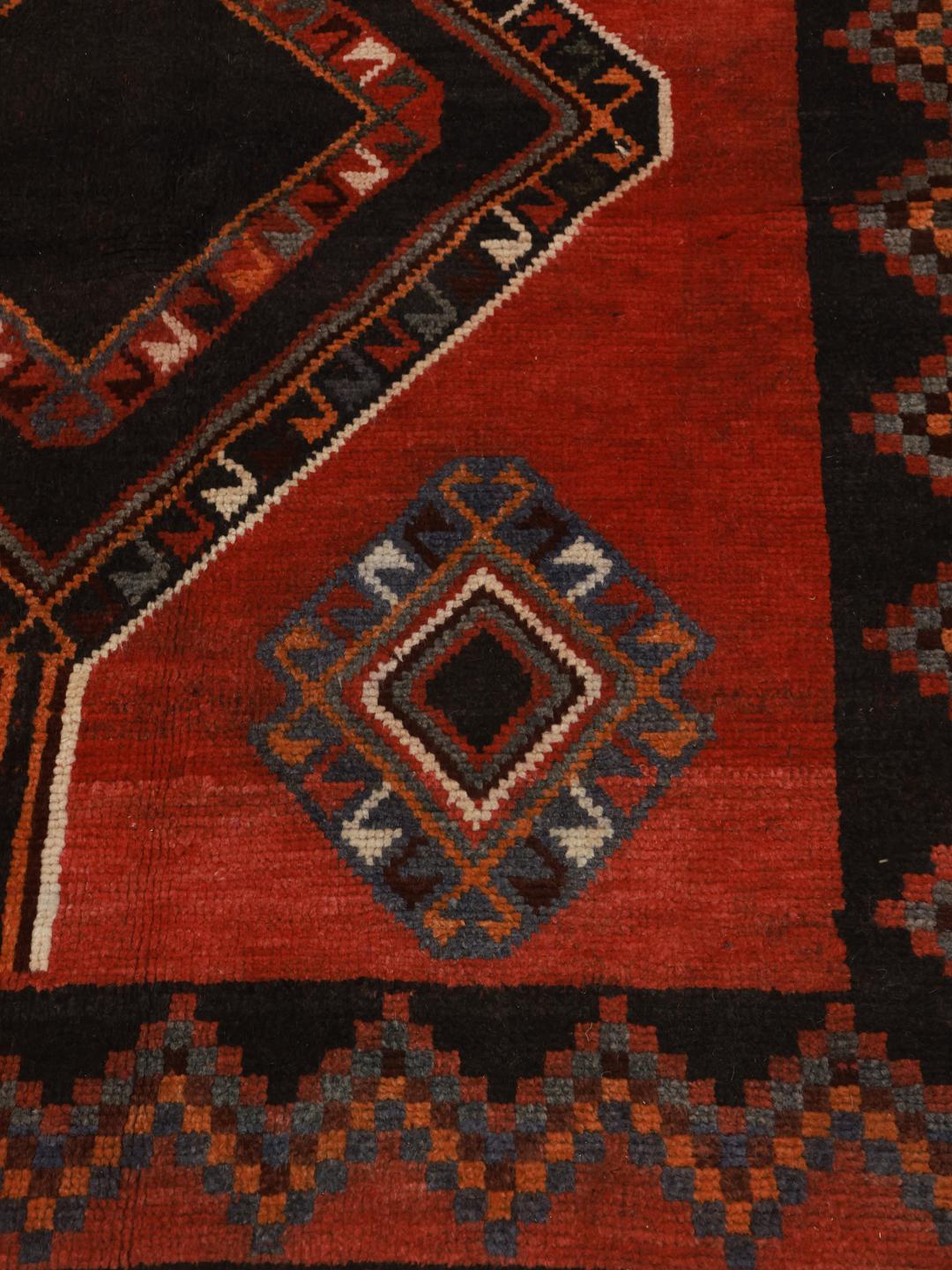 Hand-knotted Shiraz rug from the Middle East featuring geometric diamond patterns in red and black
