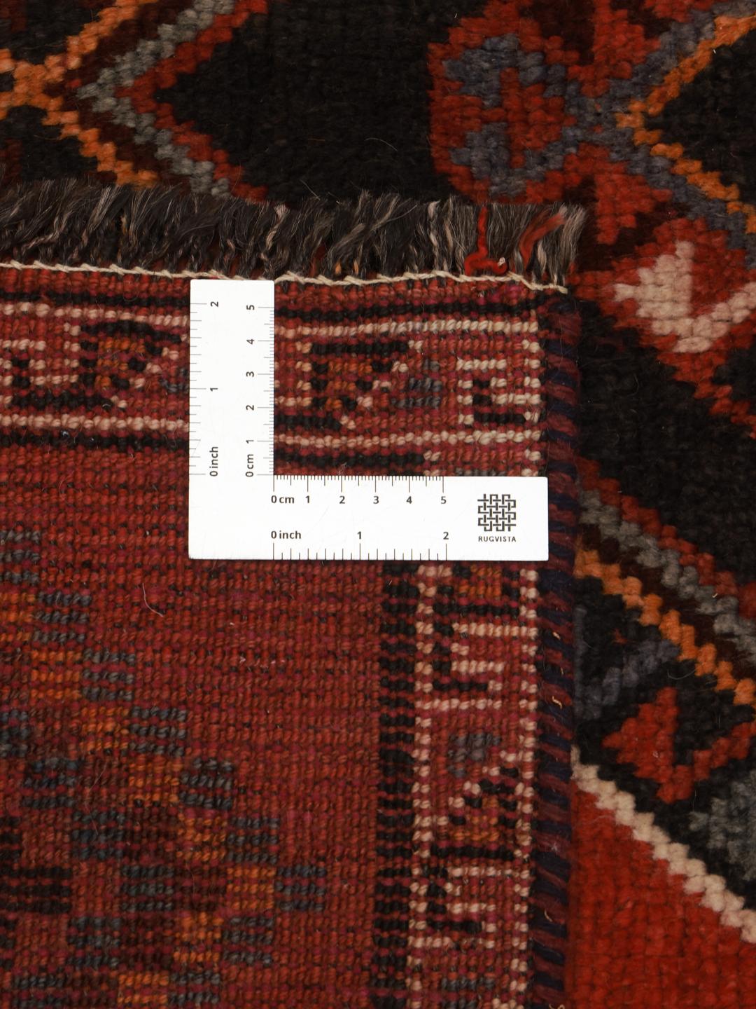 Hand-knotted Shiraz rug from the Middle East featuring geometric diamond patterns in red and black