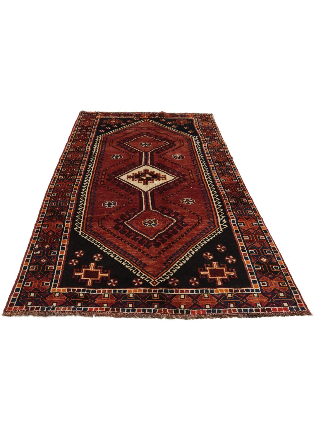 A hand-knotted Shiraz rug from the Middle East featuring a red and black geometric design.
