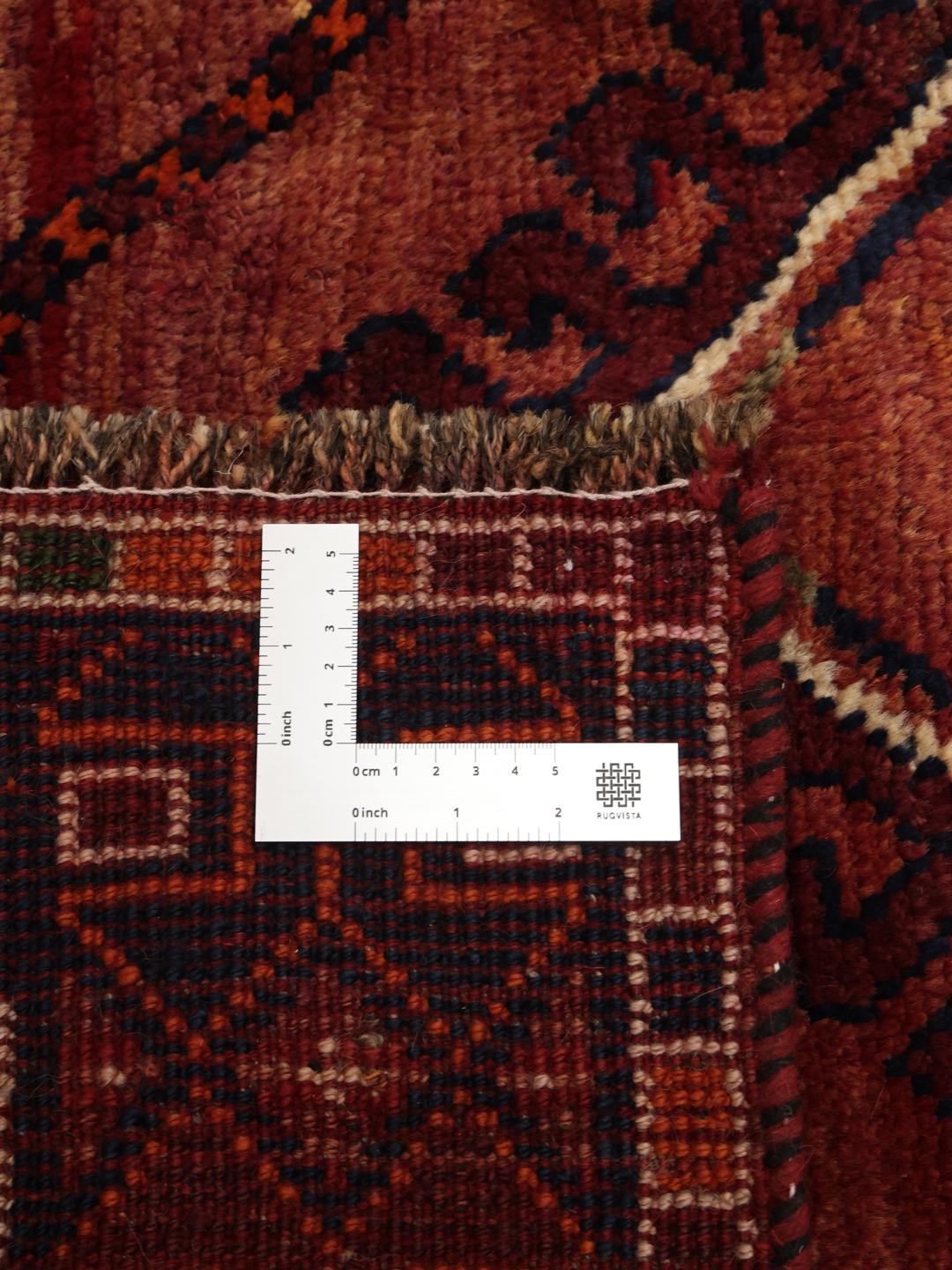 A hand-knotted Shiraz rug from the Middle East featuring a red and black geometric design.