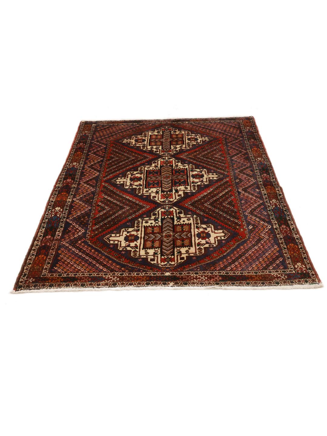 A hand-knotted Shahrbabak rug from the Middle East in deep red and blue tones.