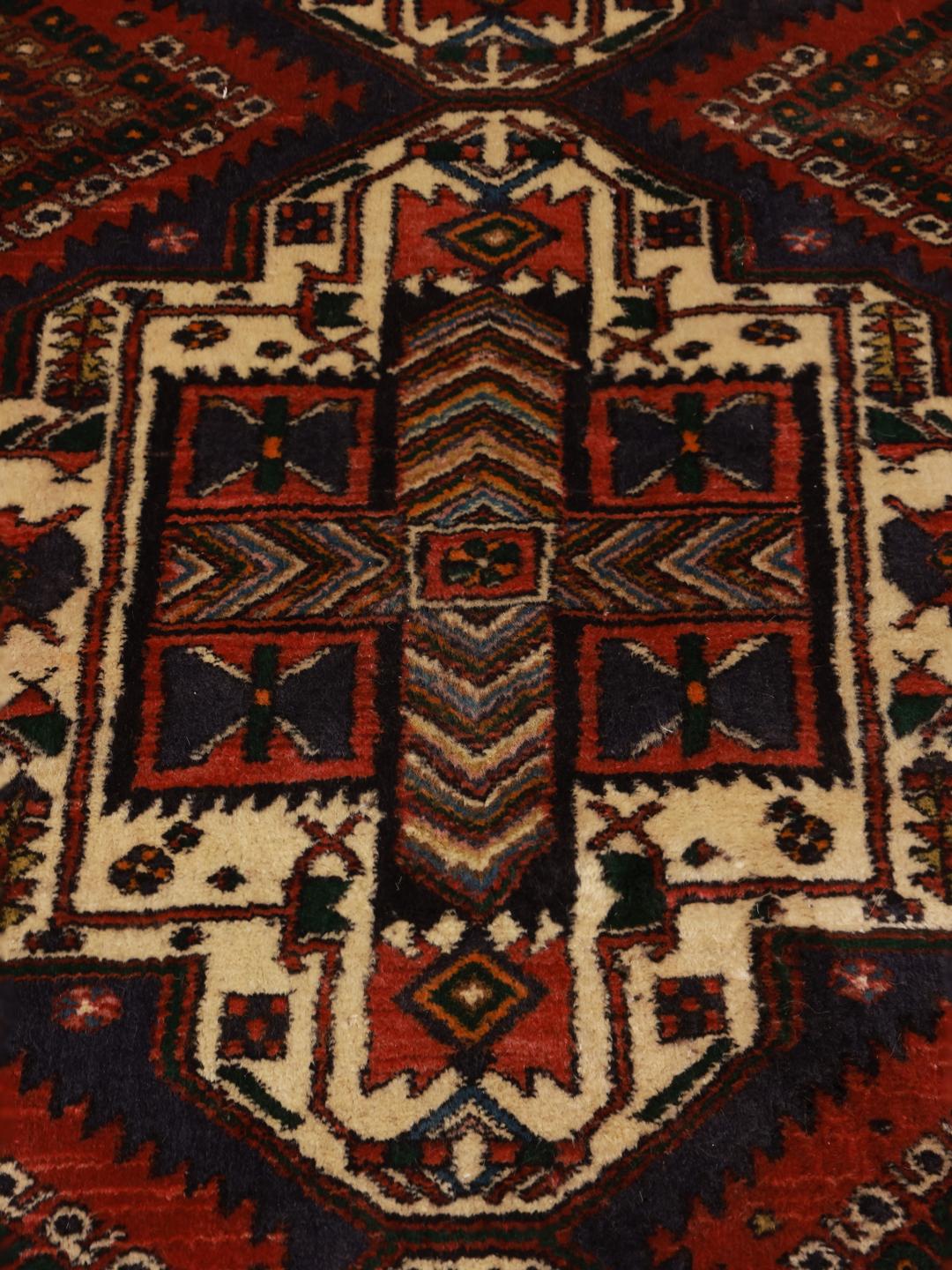 A hand-knotted Shahrbabak rug from the Middle East in deep red and blue tones.