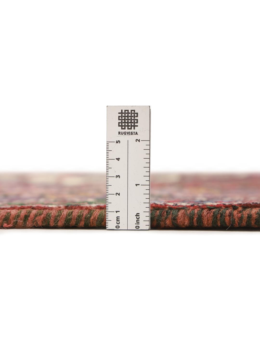 A hand-knotted Shahrbabak rug from the Middle East in deep red and blue tones.