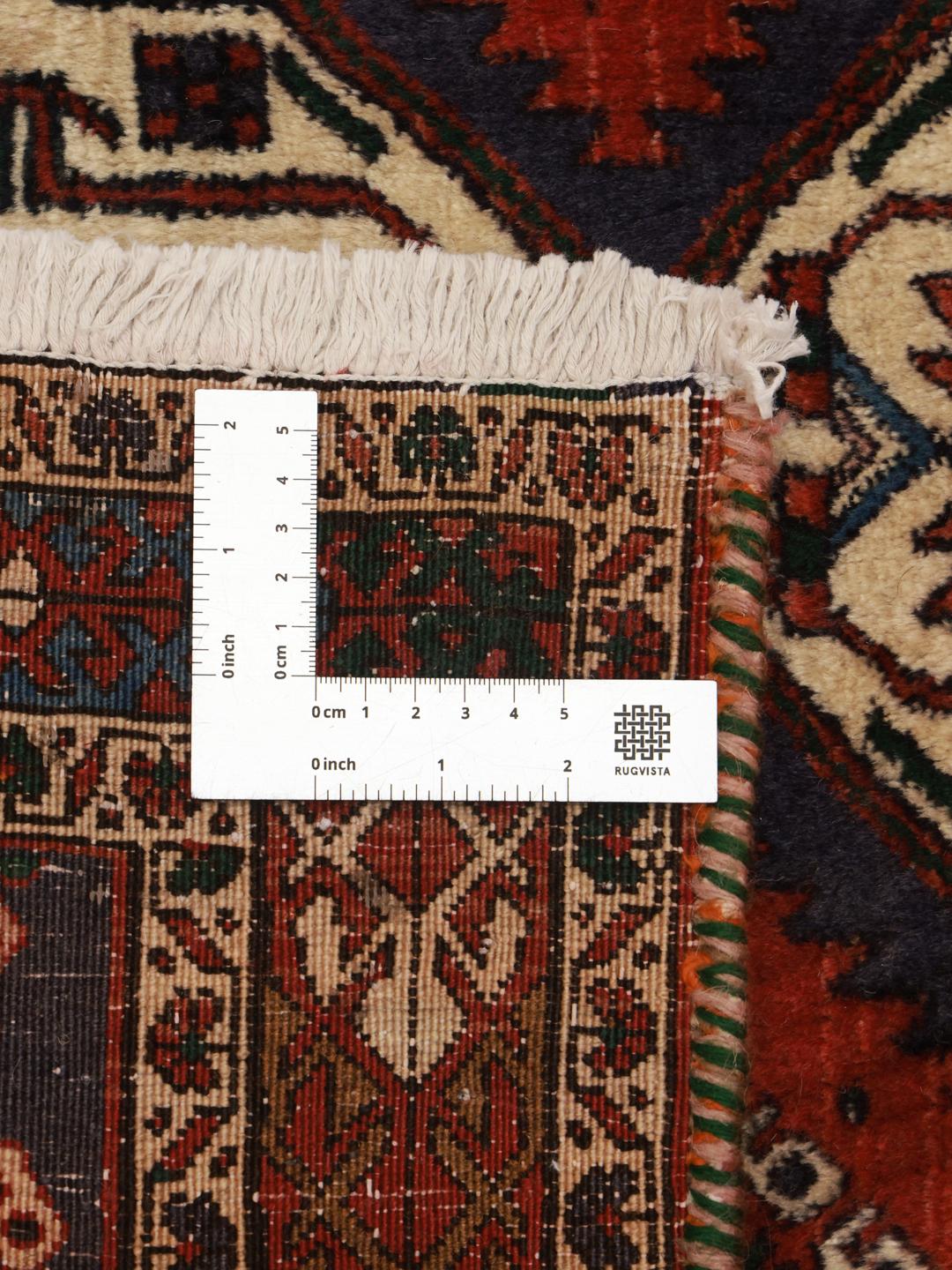 A hand-knotted Shahrbabak rug from the Middle East in deep red and blue tones.