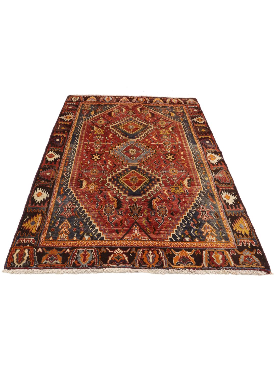 Handgeknoopt tapijt uit het Midden-Oosten in dieprode en blauwe tinten met traditionele geometrische patronen.