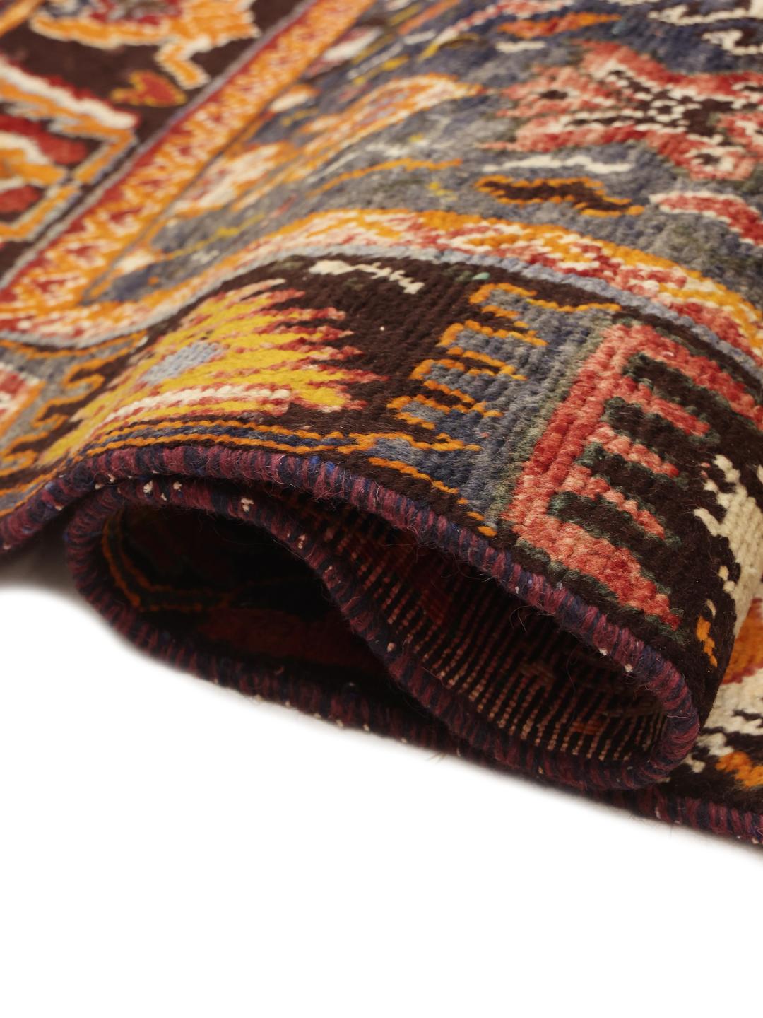 Handgeknoopt tapijt uit het Midden-Oosten in dieprode en blauwe tinten met traditionele geometrische patronen.