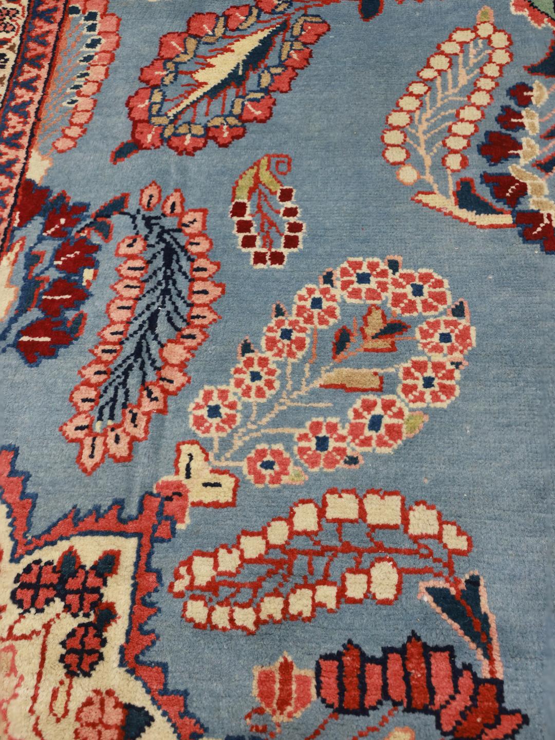 Een handgeknoopt Lillian-tapijt uit het Midden-Oosten met een blauw veld en bloemmotief