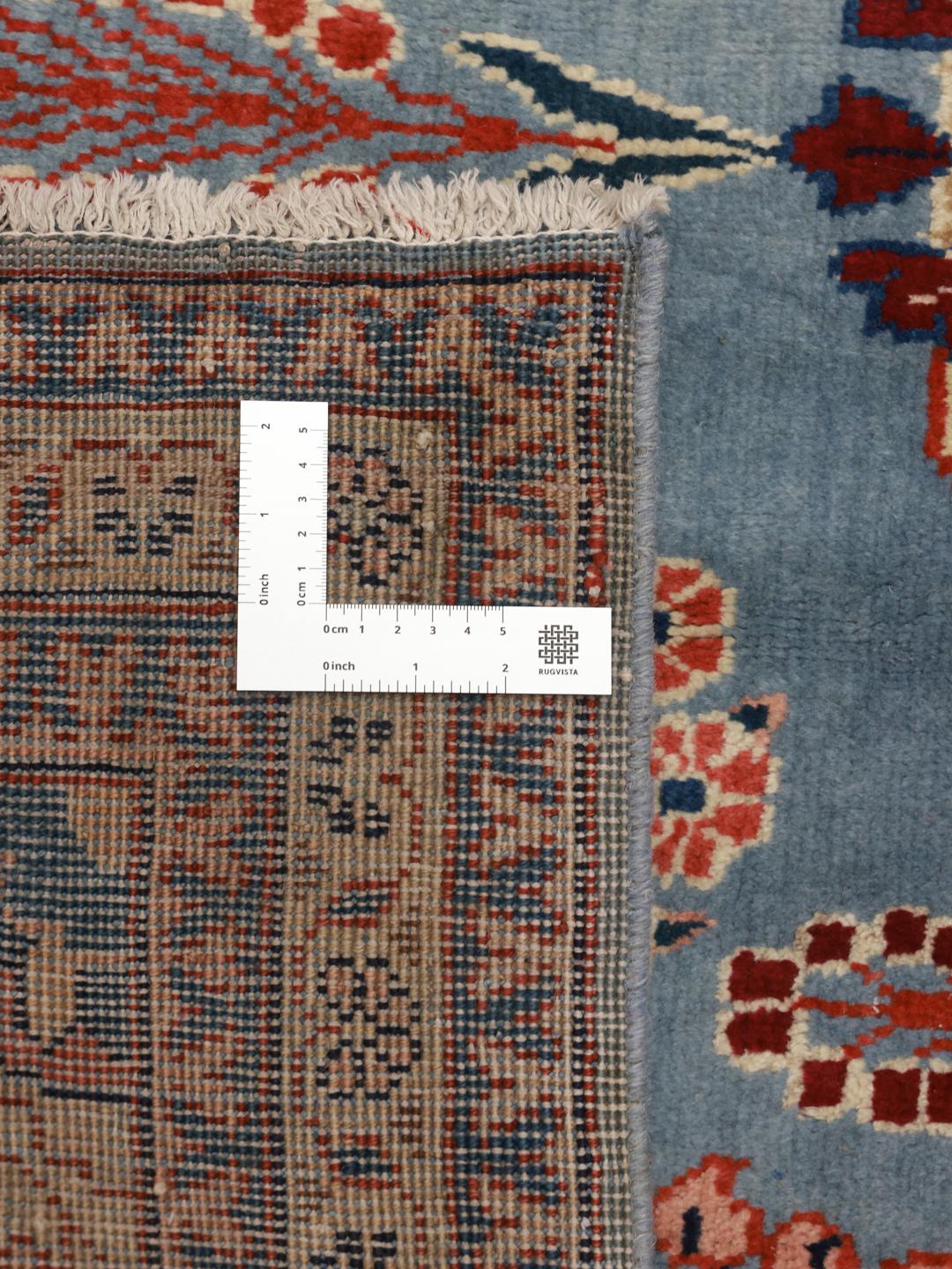 Een handgeknoopt Lillian-tapijt uit het Midden-Oosten met een blauw veld en bloemmotief