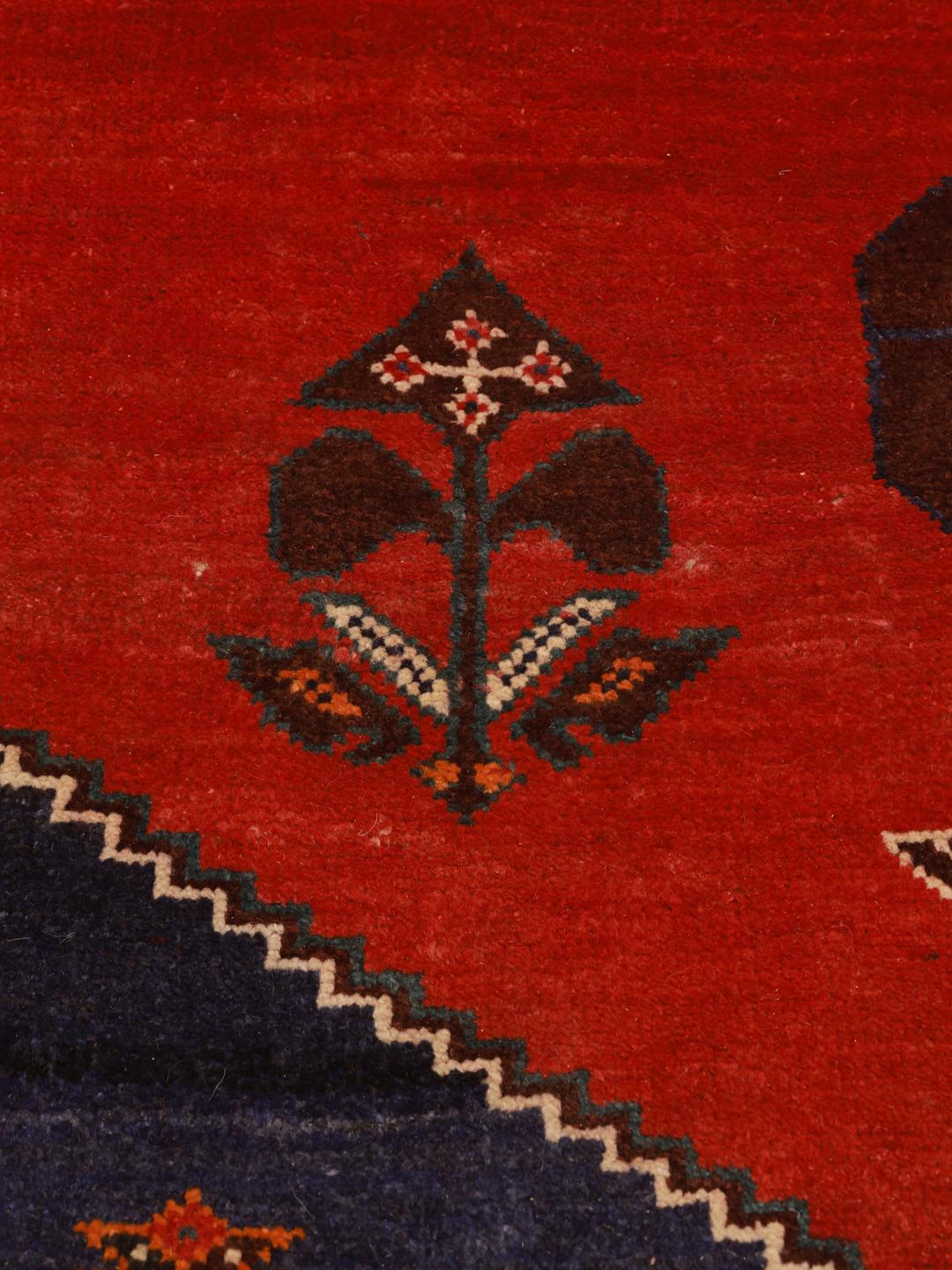 Hand-knotted Qashqai rug from the Middle East in red and deep blue tones