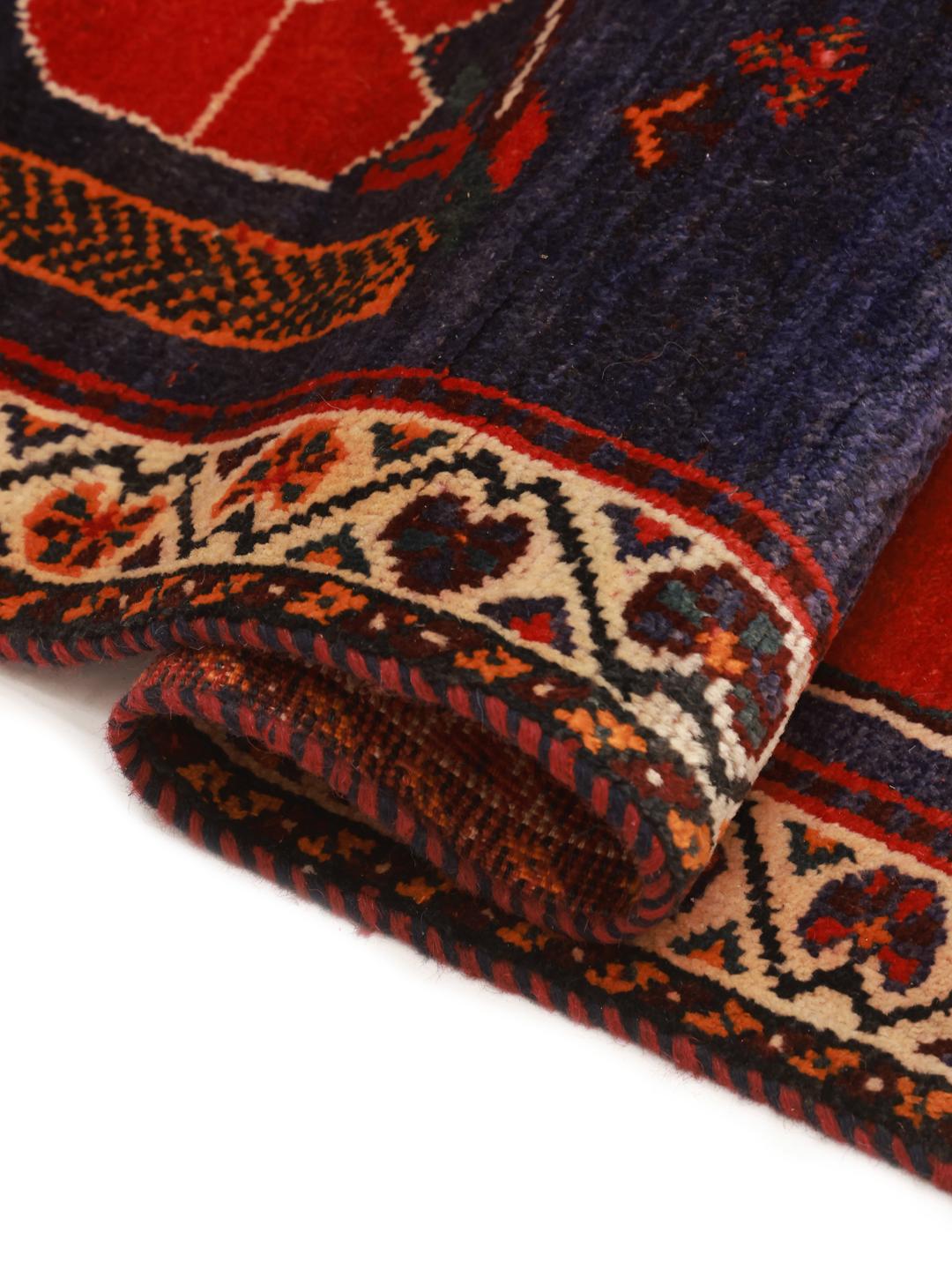 Hand-knotted Qashqai rug from the Middle East in red and deep blue tones