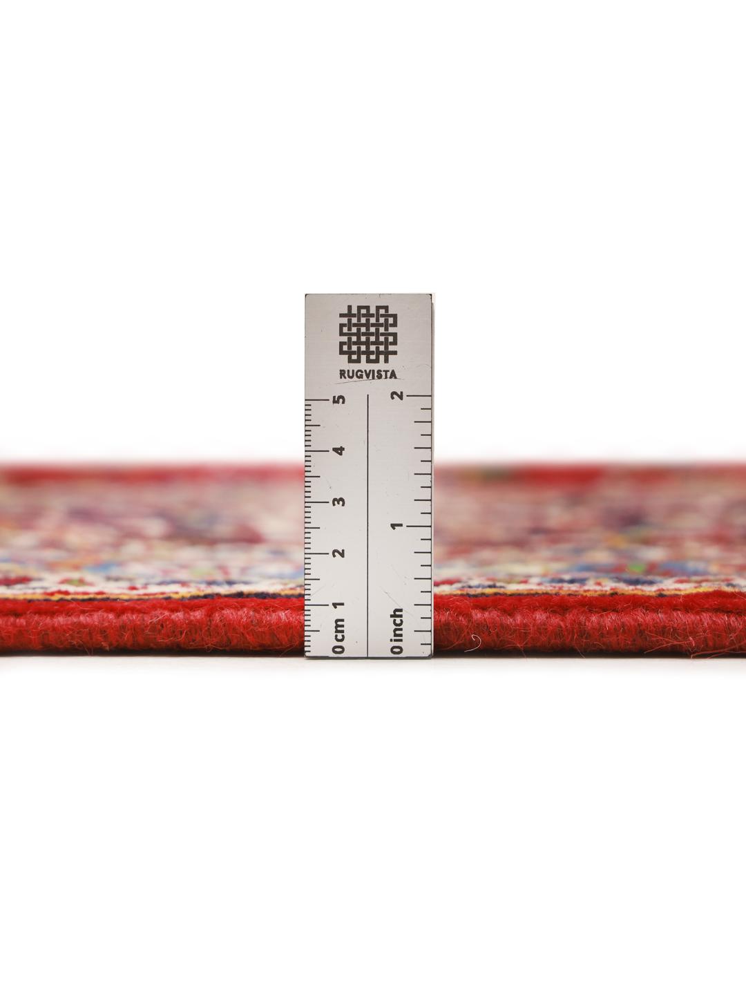 Hand-knotted Keshan rug from the Middle East with a red field and traditional floral medallion.
