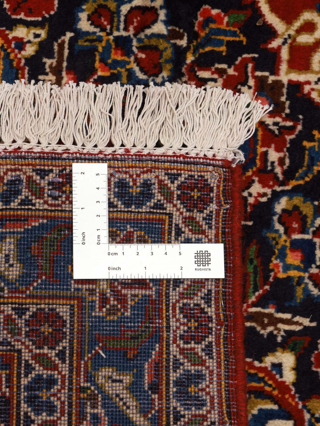 Hand-knotted Keshan rug from the Middle East with a red field and traditional floral medallion.